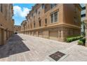 Townhouse exterior featuring brick paving, garages, and beautiful landscaping at 2221 Soho Bay Ct, Tampa, FL 33606