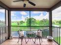 Balcony with wrought iron table and chairs overlooking the golf course and lake at 2400 Feather Sound Dr # 635, Clearwater, FL 33762