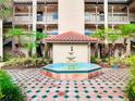 Exterior of a building with a fountain, red tiled roof, and well maintained courtyard at 2400 Feather Sound Dr # 635, Clearwater, FL 33762