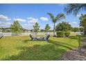Spacious, fenced backyard with a well-maintained lawn and a cozy fire pit area at 26701 Winged Elm Dr, Wesley Chapel, FL 33544