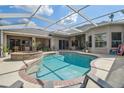 A screened in pool and spa with outdoor seating and covered patio area at 26701 Winged Elm Dr, Wesley Chapel, FL 33544