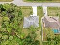 Aerial view showcasing the home's roof, driveway, and surrounding lush landscaping at 2675 Cherokee St, North Port, FL 34286