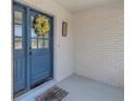 Close-up of a vibrant blue front door with decorative wreath, welcome mat and stylish house number at 3035 Annadale, Brandon, FL 33511