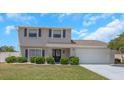 Charming two-story home boasts a blue door, complemented by a two-car garage and a well-manicured lawn at 3035 Annadale, Brandon, FL 33511