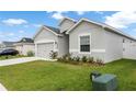 Charming single-story home with a gray exterior, a two-car garage, and a well-manicured lawn at 35519 Bellington Blvd, Zephyrhills, FL 33541