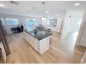 Open-concept layout featuring a kitchen island with seating and views of the living area and backyard at 4715 W Chapin Ave, Tampa, FL 33611