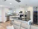 Bright, open kitchen with stainless steel appliances, an island with seating, and white cabinets at 4715 W Chapin Ave, Tampa, FL 33611
