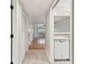 Neutral hallway leading to bright living space; view of open kitchen with tile floors and white appliances at 4946 Mill Pond Rd # 3180, Wesley Chapel, FL 33543