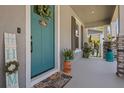 Inviting front porch with a blue door, potted plants, and a welcoming welcome mat at 710 W River Heights Ave, Tampa, FL 33603