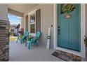 Cozy front porch with comfortable blue chairs, side table and charming décor at 710 W River Heights Ave, Tampa, FL 33603