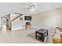 Spacious living room with tile flooring, staircase, and a ceiling fan for optimal comfort at 732 Kensington Lake Cir, Brandon, FL 33511