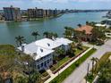 Wide aerial view of a luxury waterfront property with a boat dock and manicured lawn near the bay at 755 Bay Esplanade, Clearwater Beach, FL 33767