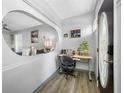 Inviting entryway with stylish wood floors, a unique oval cutout in the wall, and a functional workspace near the front door at 8444 8Th N Way, St Petersburg, FL 33702