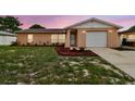 Charming single-story home featuring a well-manicured lawn and an attached one-car garage at 8531 Woodcrest Dr, Port Richey, FL 34668