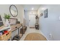 Bright foyer with a decorative mirror, console table, and coat rack, creating a welcoming entrance at 9411 Lemon Drop Loop, Sun City Center, FL 33573