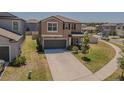 Inviting two-story house with a long driveway, a garage, and manicured front yard at 9411 Lemon Drop Loop, Sun City Center, FL 33573