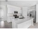 Modern kitchen with stainless steel appliances, white cabinets and large center island at 11257 Linden Depot Rd, San Antonio, FL 33576