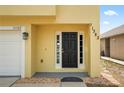 Close up of front door, sidelights, address numbers and view of the two car garage at 11323 Ivy Flower Loop, Riverview, FL 33578