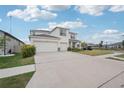 Bright exterior view showcasing a three-car garage, lush lawn and tidy landscaping at 13055 Willow Grove Dr, Riverview, FL 33579