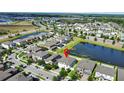 Aerial view of a serene suburban community with a pond and well-maintained landscaping, solar panels, and neighborhood at 13130 Monach Isles Dr, Riverview, FL 33579