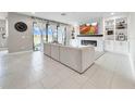 Bright and airy living room showcasing a fireplace, built-in shelving, neutral color palette, and seamless indoor-outdoor living at 13130 Monach Isles Dr, Riverview, FL 33579