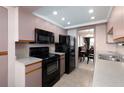 Efficient kitchen design with modern black appliances, functional layout, and adjacent dining area at 1316 Pasadena S Ave # 303, South Pasadena, FL 33707