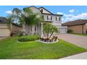 Beautiful lawn showcasing lush landscaping and a charming gray two-story home with a three-car garage at 13311 Orca Sound Dr, Riverview, FL 33579