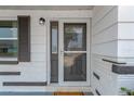 Close-up of the front door with storm door and decorative window, showcasing the home's entrance at 13612 Veronica Dr, Hudson, FL 34667