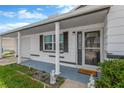 Welcoming front porch with columns, decorative statues, and a 'HOME' doormat at 13612 Veronica Dr, Hudson, FL 34667