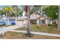 Charming one-story home with a metal roof, an attached two-car garage, and mature landscaping at 1432 Windjammer Pl, Valrico, FL 33594