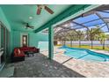A cozy covered patio, complete with comfortable seating, overlooks a sparkling screened-in pool at 1709 Sunset Dr, Tarpon Springs, FL 34689