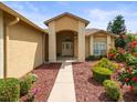 Inviting front entrance with meticulous landscaping and a brick-accented walkway at 18514 Hidden Pines Way, Hudson, FL 34667