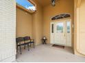 Covered front porch featuring a seating area and decorative glass front door at 18514 Hidden Pines Way, Hudson, FL 34667