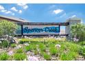 Inviting community sign for Spencer Creek, surrounded by beautiful landscaping and vibrant flowers at 1876 Colding Dr, Ruskin, FL 33570