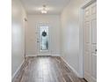 Bright hallway with wood-look tile flooring leading to the front door at 19041 Alfaro Loop, Spring Hill, FL 34610