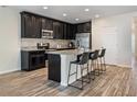 Stylish kitchen featuring dark cabinets, granite countertops, and stainless steel appliances at 19041 Alfaro Loop, Spring Hill, FL 34610