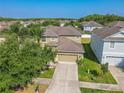 Two story home with manicured lawn featuring two car garage, palm tree, and landscape features at 20404 Autumn Fern Ave, Tampa, FL 33647