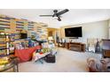 Spacious living room featuring a decorative brick wall, ceiling fan, and entertainment center at 2078 Shadow Ln, Clearwater, FL 33763