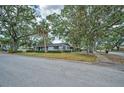 Exterior street view of a well-kept home with mature trees and a charming, inviting curb appeal at 2880 81St N St, St Petersburg, FL 33710
