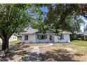 Charming single-story home with a tidy lawn and flowerbeds in front of the windows at 308 E 121St Ave, Tampa, FL 33612
