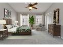 Spacious bedroom with ceiling fan, natural light, comfortable seating area, and decor at 308 S Bungalow Park Ave # B, Tampa, FL 33609
