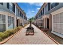 Beautiful townhomes with brick-paved walkway, landscaping, and black bench at 308 S Bungalow Park Ave # B, Tampa, FL 33609
