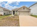 Inviting single-story home with a well-manicured lawn, a cozy front porch, and a convenient two-car garage at 32713 Brooks Hawk Ln, Wesley Chapel, FL 33543