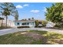 Charming single-story home with a circular driveway, well-manicured landscaping, and a light-colored facade at 3555 Belle Vista E Dr, St Pete Beach, FL 33706