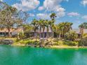 Home's backyard offers scenic lake views framed by tall palm trees, creating a tranquil outdoor living space at 3558 65Th Avenue E Cir, Sarasota, FL 34243