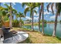 Lakeside backyard featuring palm trees, a fire pit, and comfortable seating for relaxing outdoor moments at 3558 65Th Avenue E Cir, Sarasota, FL 34243