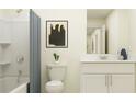 Bright bathroom featuring a shower with curtain, a toilet, and a vanity with white cabinets at 36017 Joseph Blake St, Zephyrhills, FL 33541