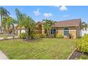Single Gathering home showcasing its landscaped front yard with lush green lawn and trees at 4410 Foxboro Dr, New Port Richey, FL 34653