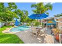Wonderful outdoor living space with a refreshing pool, patio dining set, covered area, and lush landscaping at 4721 W Lawn Ave, Tampa, FL 33611