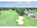 Scenic aerial view of a home backing onto a golf course surrounded by lush greenery at 7099 Crested Orchid Dr, Brooksville, FL 34602